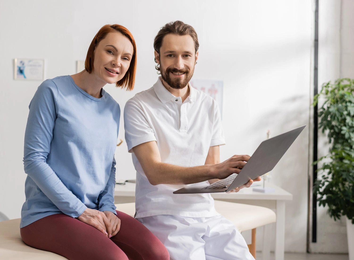 chiropractor with patient and laptop