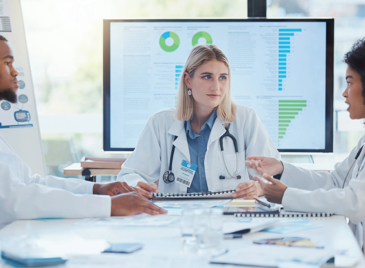 doctor sitting round table with charts