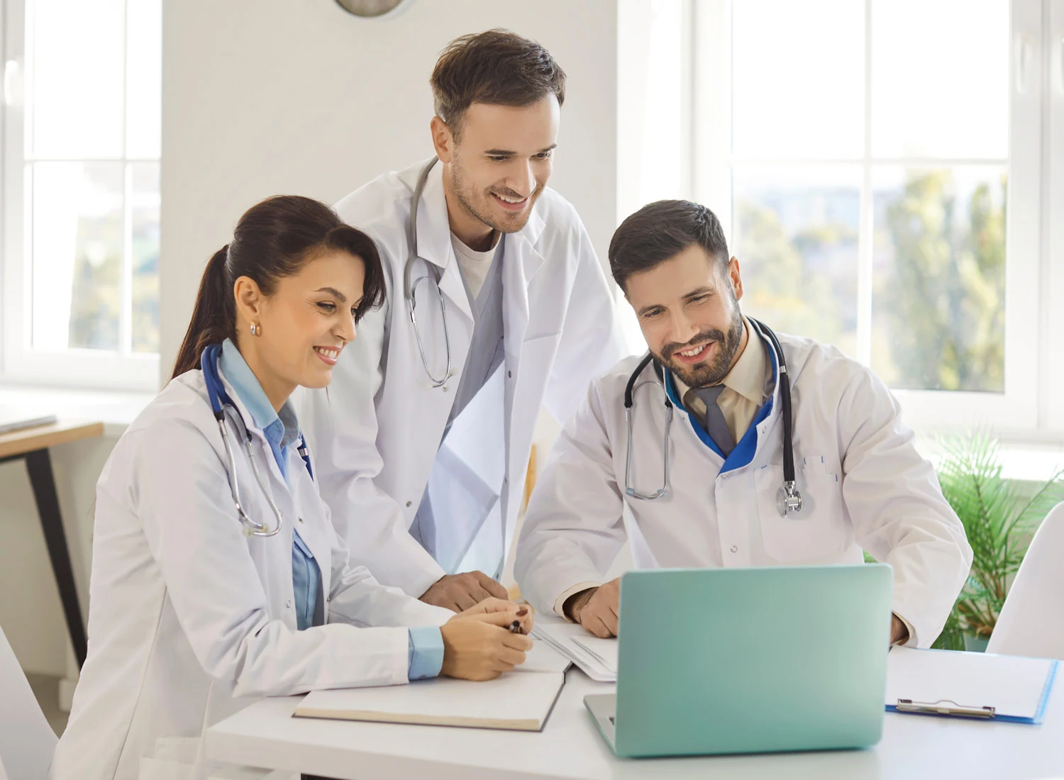 doctors sitting around laptop
