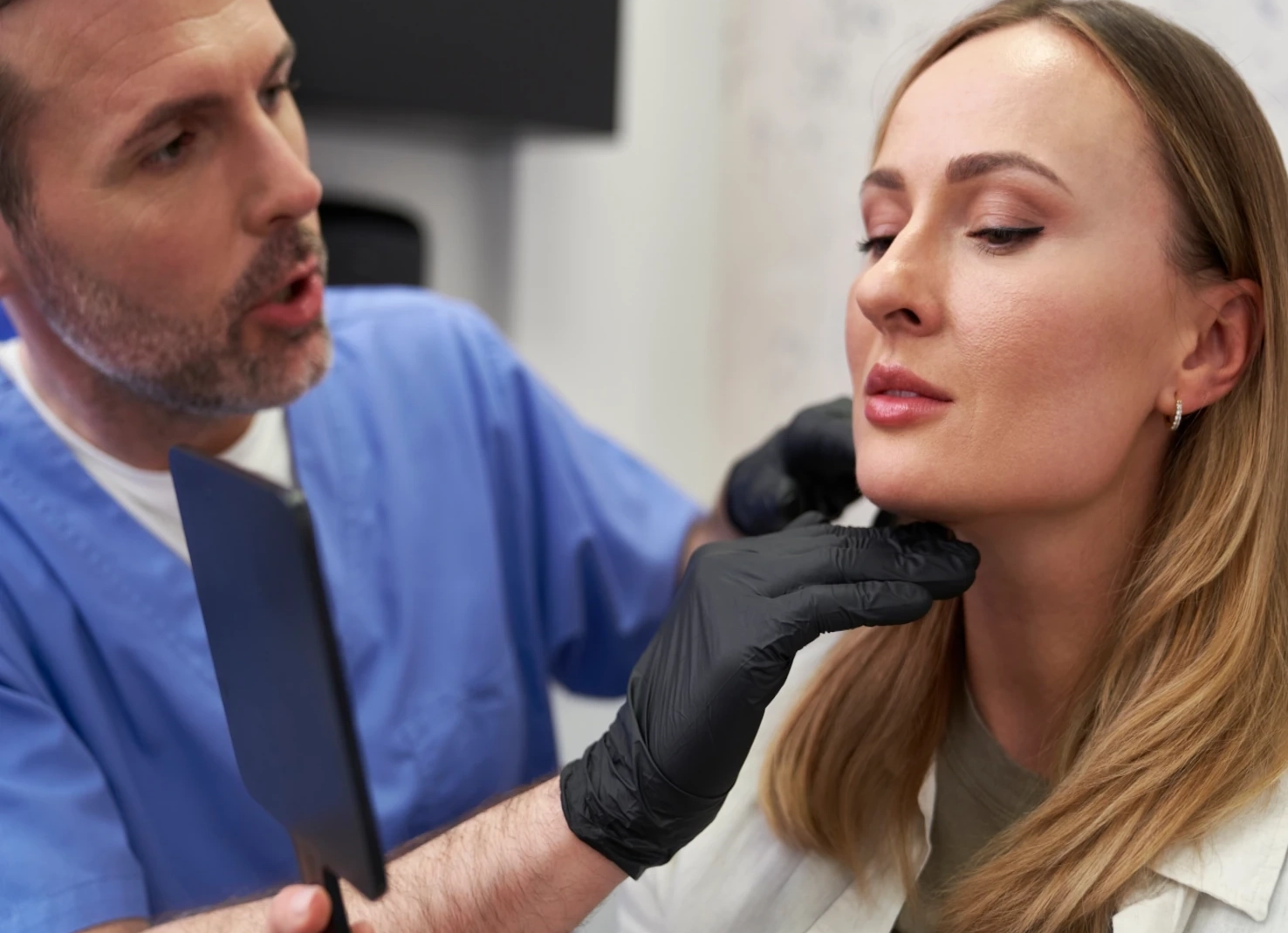 doctor in med spa looking at patient face for injectables placement