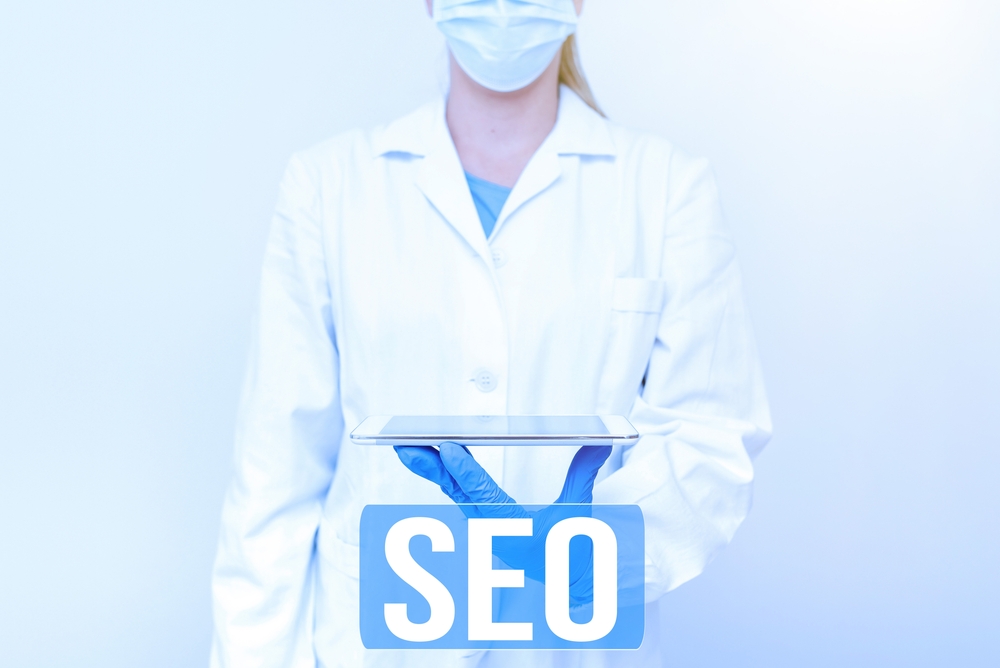 Writing displaying text Seo with doctor holding iPad